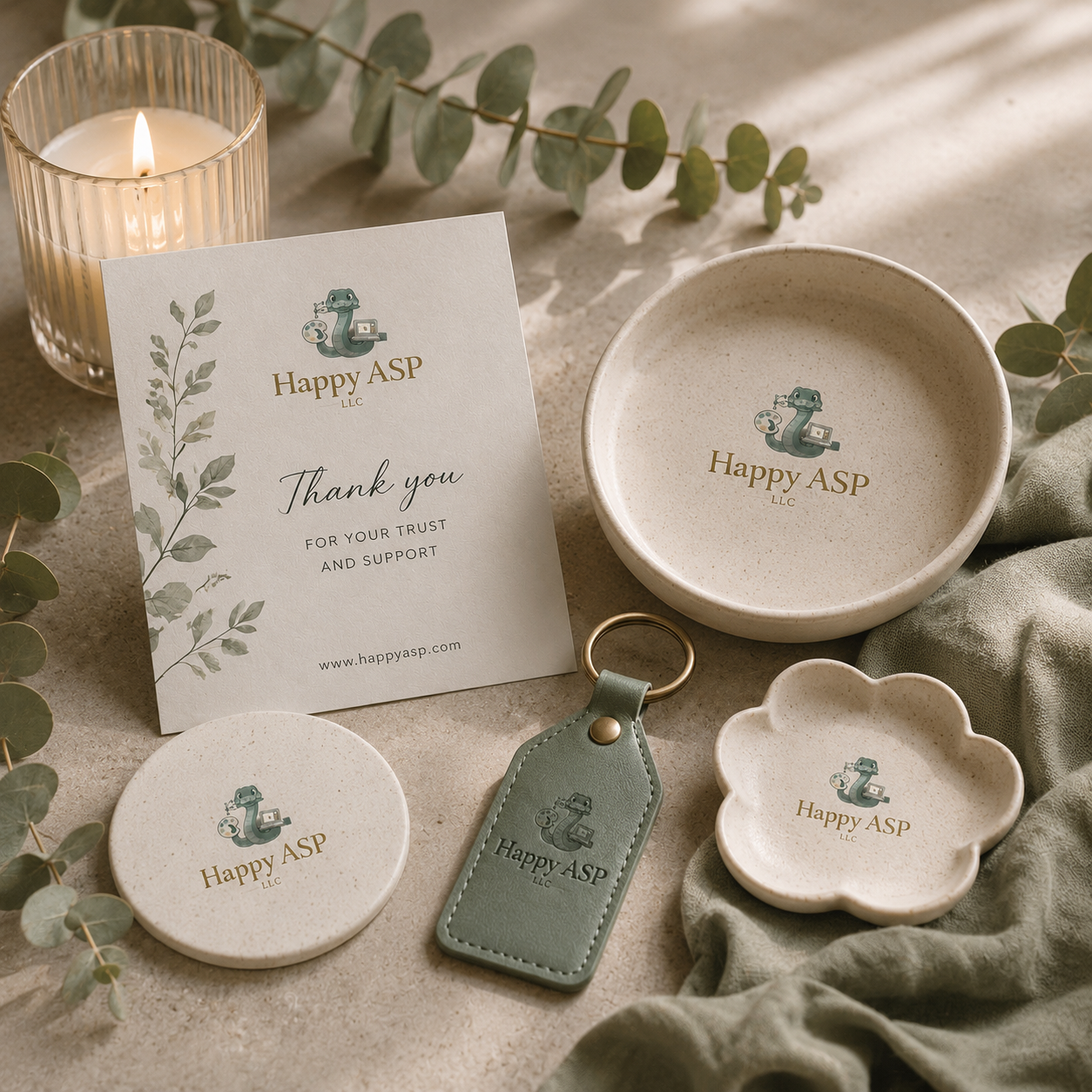 Branding suite for Happy ASP LLC: card, dish, coaster, keychain tag, and leaves on a neutral surface with warm candlelight above the greenery.